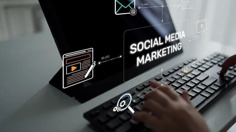 Social media manager interacting with followers on a laptop with social media icons